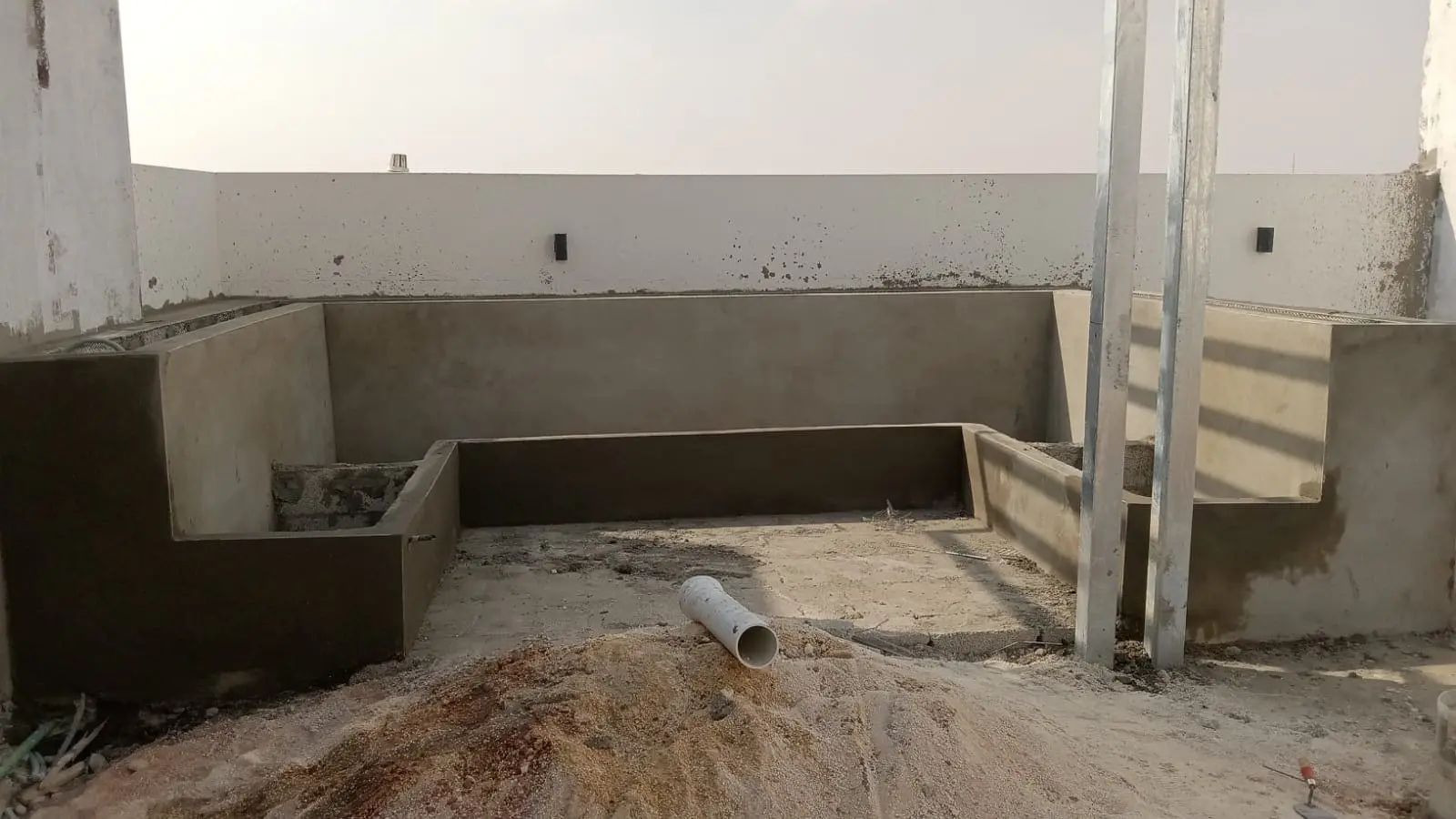 تجهيز جلسة سطح فيلا في الرياض يشمل بناء قواعد خرسانية وتركيب مظلة خارجية خلال مرحلة التشطيب