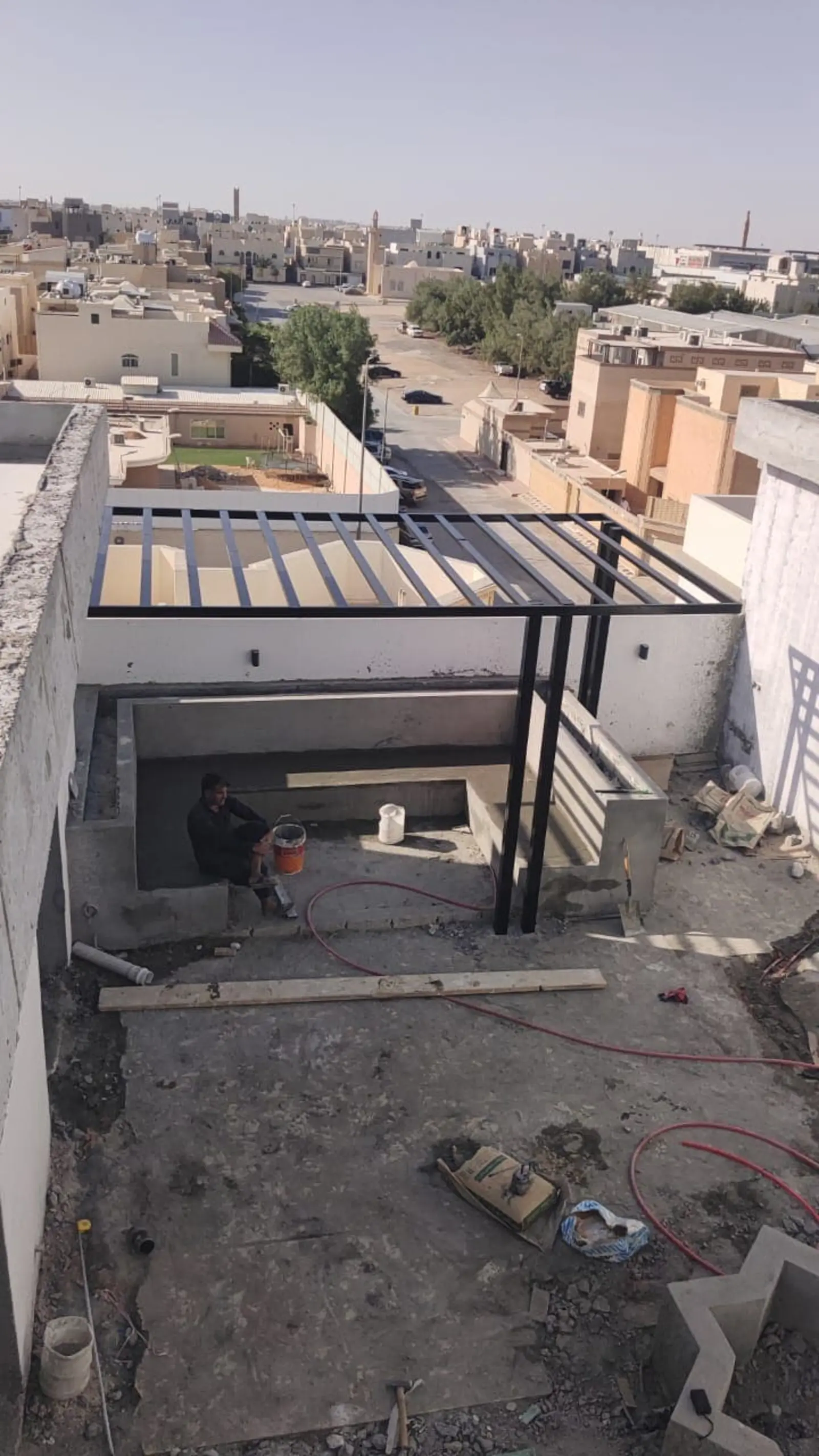 تجهيز جلسة سطح فيلا في الرياض يشمل بناء قواعد خرسانية وتركيب مظلة حديد خارجية خلال مرحلة التشطيب